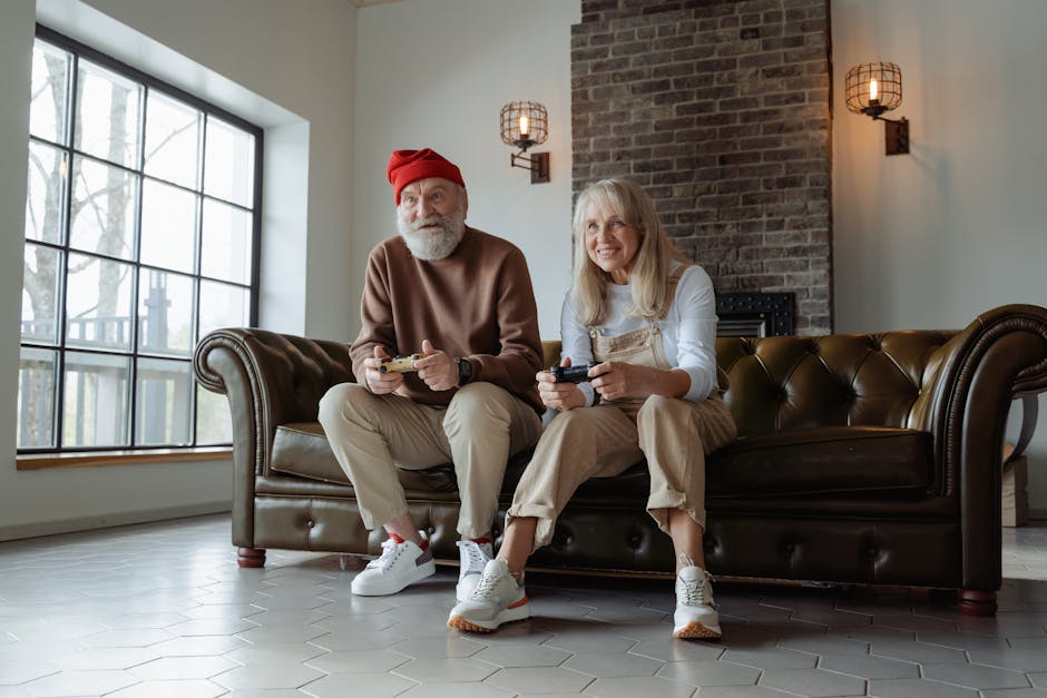 Happy senior couple playing video games on a couch, enjoying leisure time together indoors.