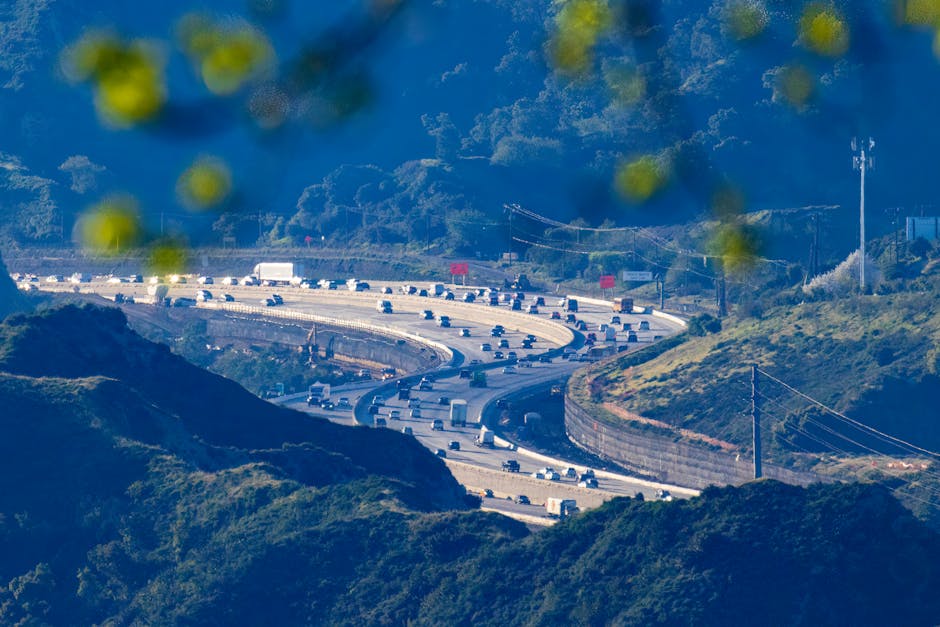 Aerial view of a bustling highway curving through mountain range.