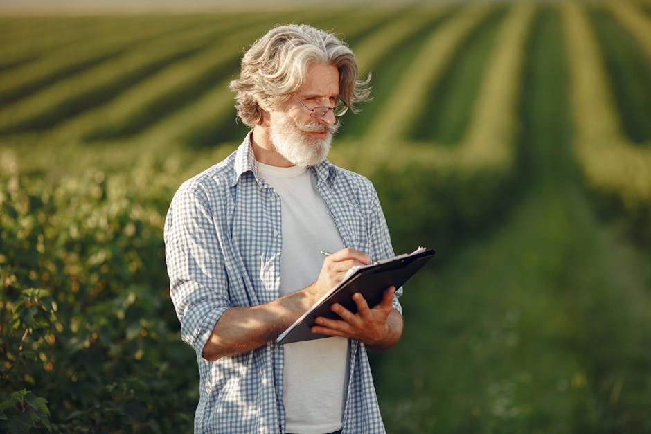 Senior man standing in a lush green field, writing on a clipboard.