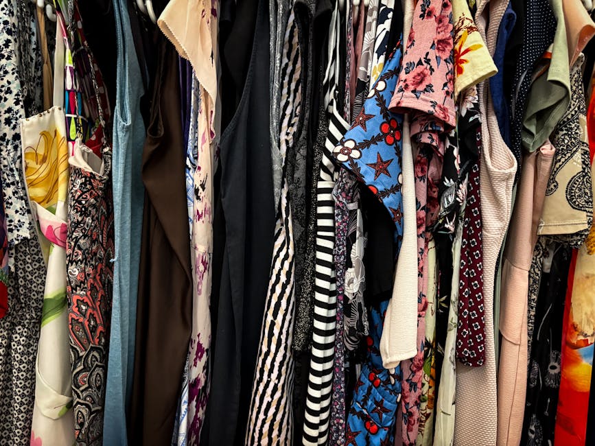 Vibrant collection of assorted vintage clothes hanging on a rack, showcasing patterns and styles.