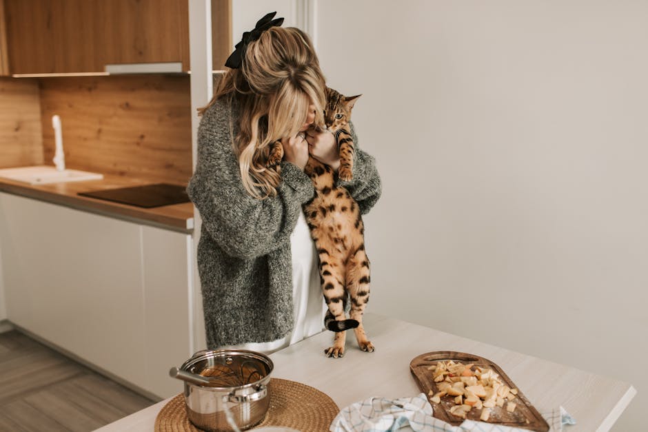 Pregnant woman hugs Bengal cat in cozy kitchen setting.