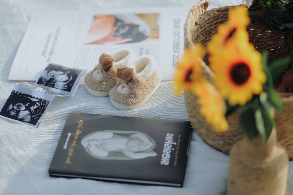 Flat lay of baby shoes, sonogram, and sunflowers, symbolizing pregnancy announcement.