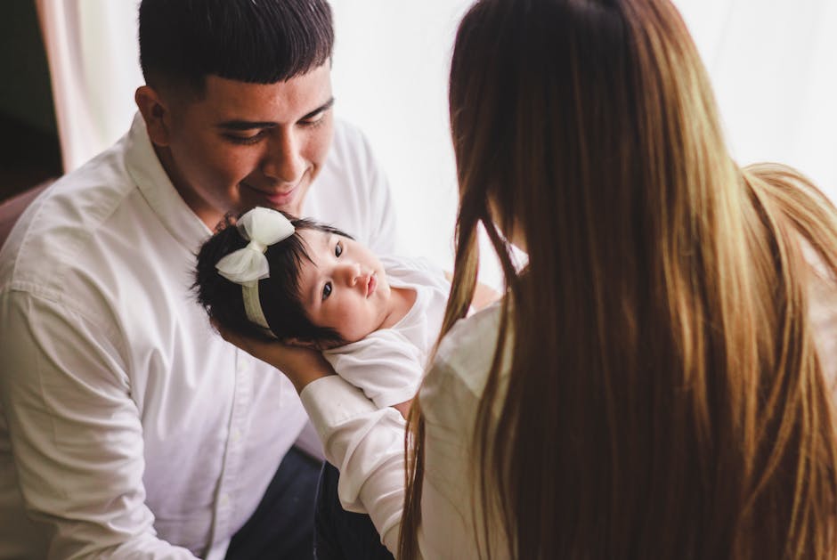 A tender moment between a young family and their baby indoors, filled with love.