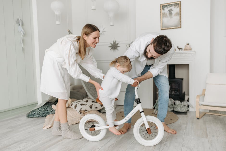 Parents assisting their child with a balance bike in a charming and cozy living room.