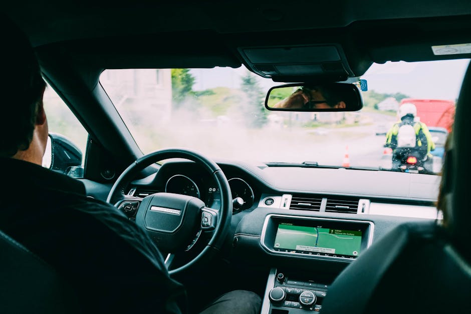 Interior view of a car with GPS navigation and traffic ahead, showcasing urban transportation.