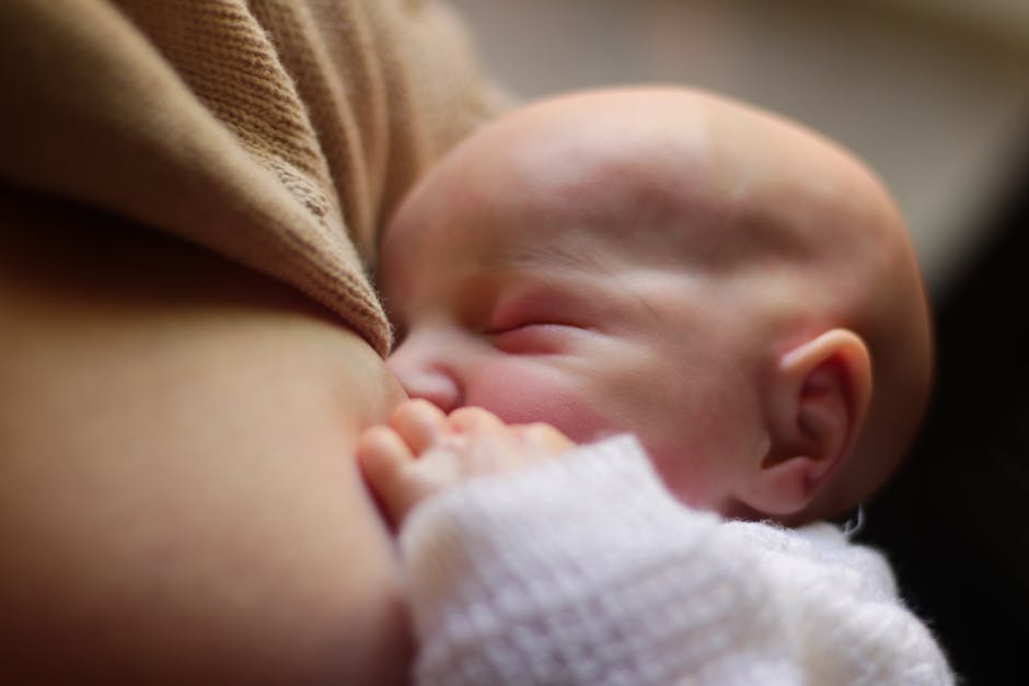 A newborn baby peacefully breastfeeding, capturing an intimate moment of mother-child bonding.