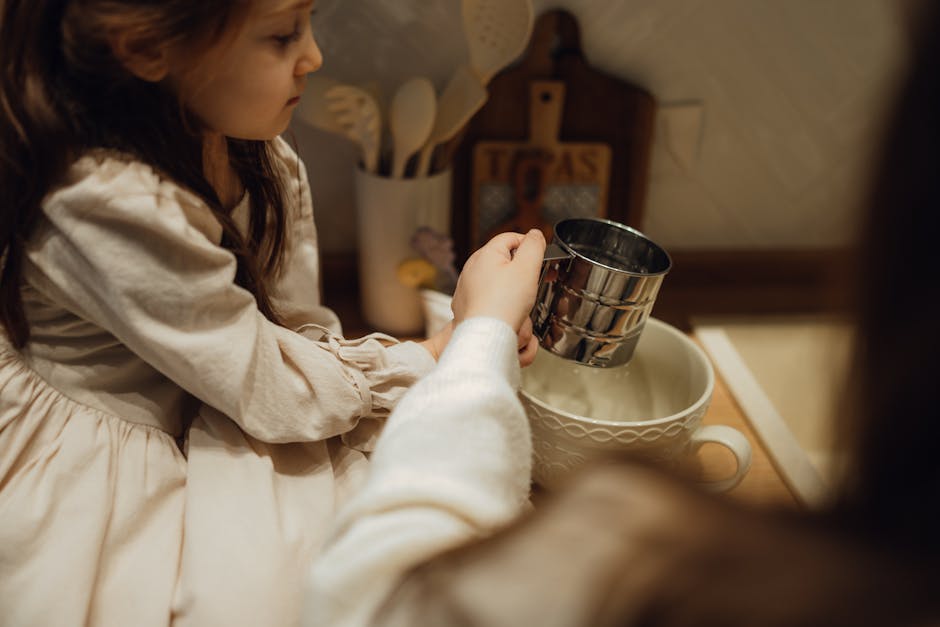 A young girl assisting with kitchen tasks, using a measuring cup in a warm, cozy setting.