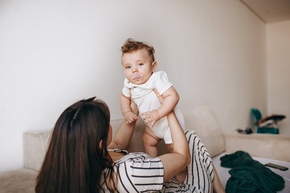 A tender moment of a mother holding her baby in a cozy living room setting.