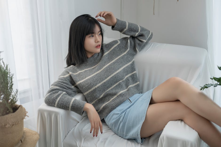 Relaxed woman in cozy sweater lounging on couch with natural light