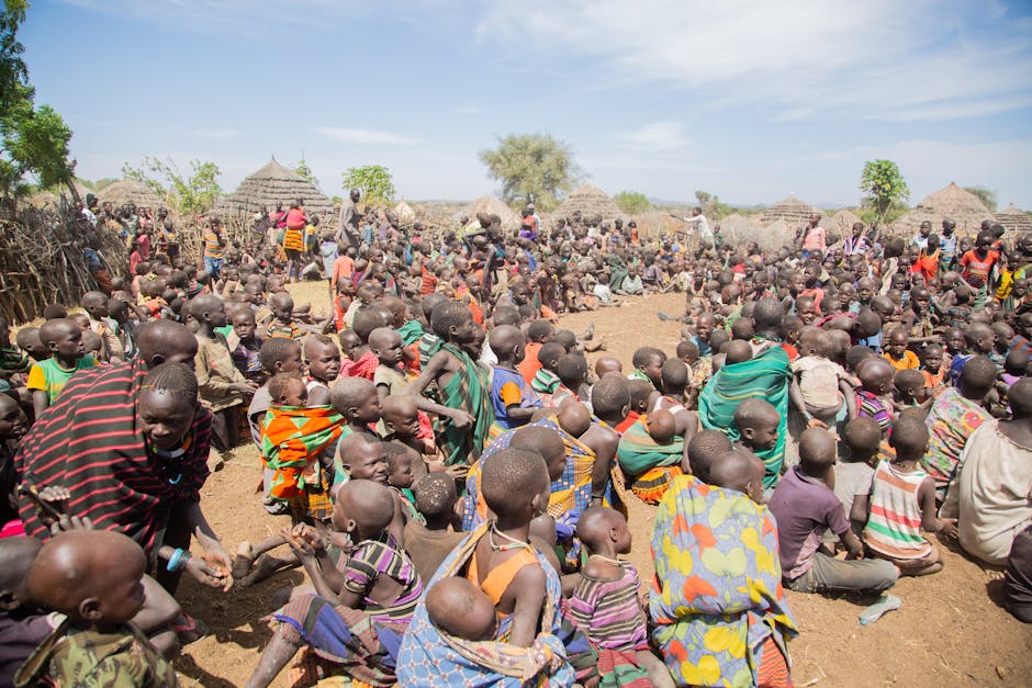A vibrant community gathering with local people sitting outdoors in an African village.