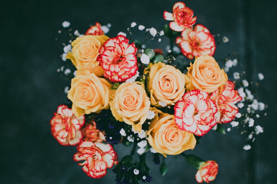 Colorful bouquet featuring yellow roses and bicolor carnations with delicate white baby's breath.