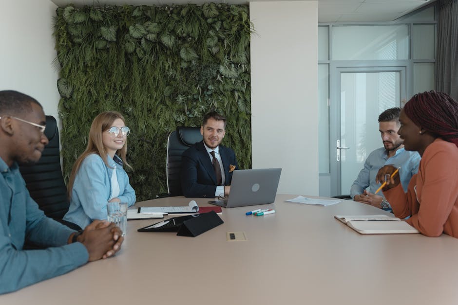 A diverse group of professionals engage in a collaborative meeting in a modern office setting.