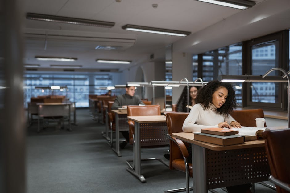 Students engaged in studying at a library, quietly reading and learning. Ideal for educational contexts.
