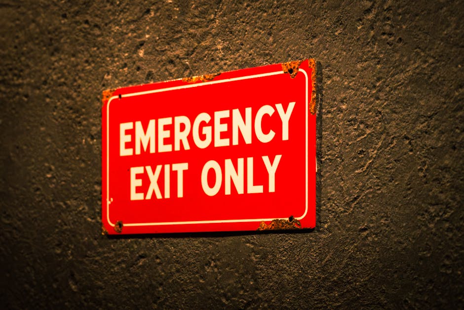 A vintage-style emergency exit sign on a textured wall, emphasizing safety and industrial themes.