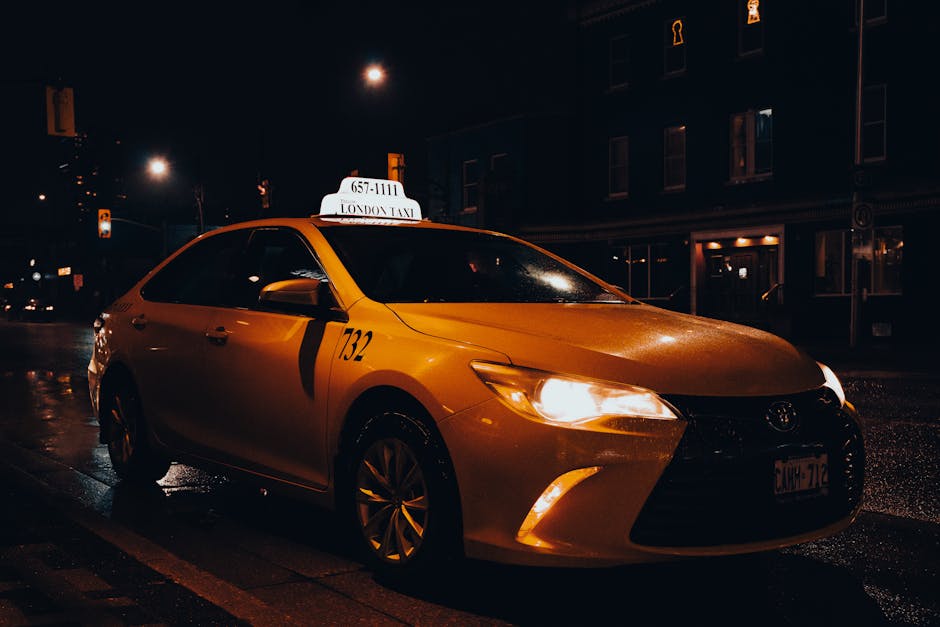 A yellow taxi waiting at night in London, Ontario, Canada. Urban transportation captured with street lights.