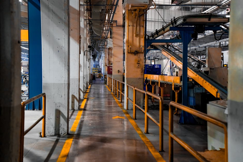 Wide view of a modern factory interior showcasing industrial machinery and conveyor systems.
