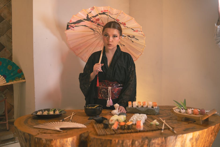 Woman in black kimono with parasol and sushi arrangement, showcasing Japanese culture.