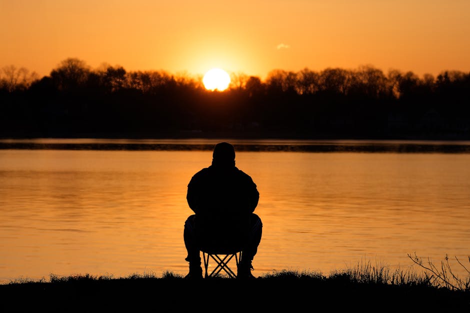Silhouette of a person meditating by the water at sunrise in Stamford, Connecticut.