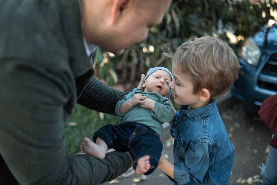 A touching scene of a young boy meeting his newborn sibling outdoors