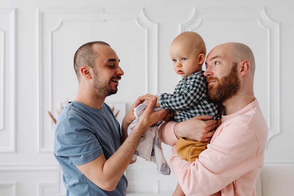 A heartfelt moment of same-sex parents lovingly holding their baby son indoors.