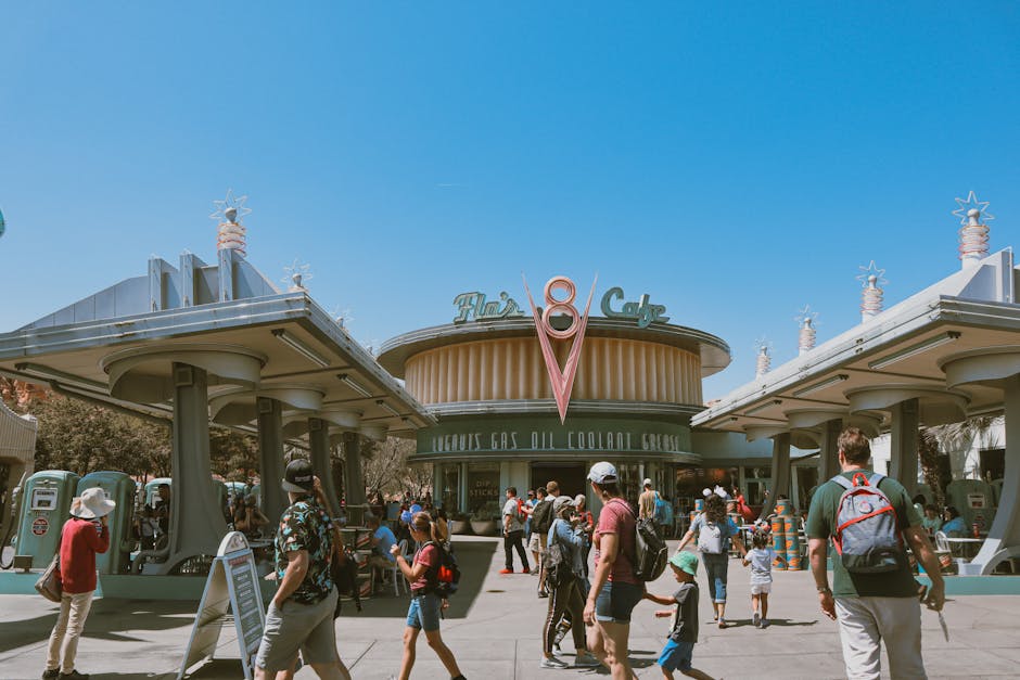 A lively scene at a retro-themed cafe entrance with tourists exploring the area on a sunny day.