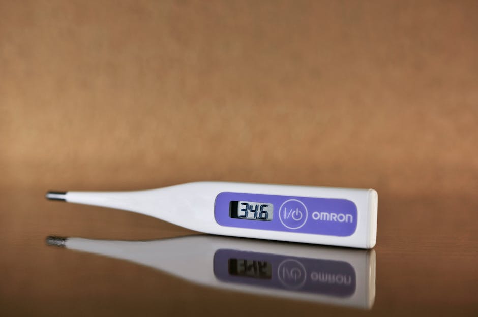 Close-up of a digital thermometer on a reflective surface showing a temperature reading.