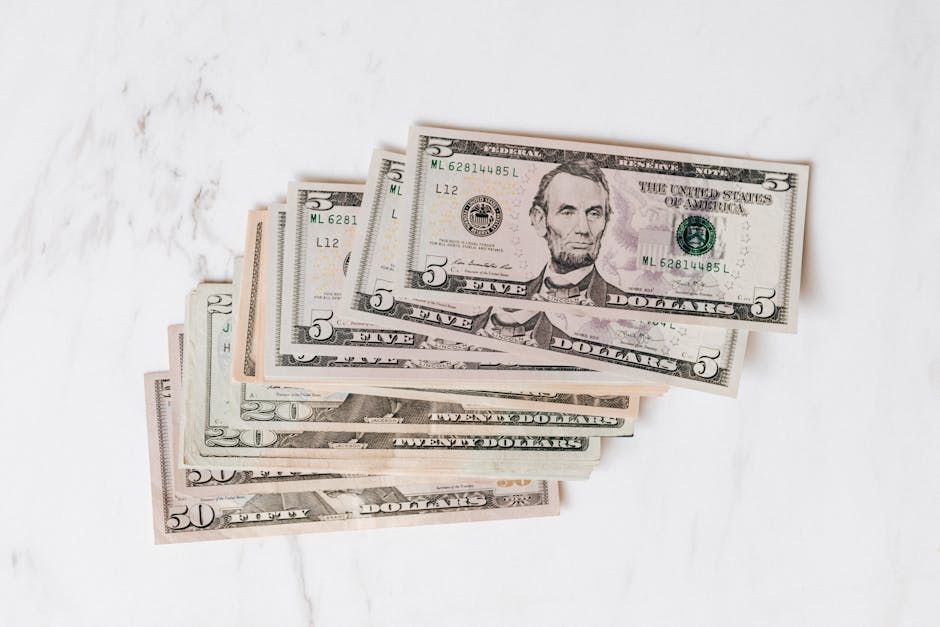 Top view heap of american dollar bills in different denominations placed on marble surface