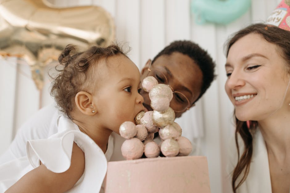 Happy family celebrating baby's first birthday with a cake.