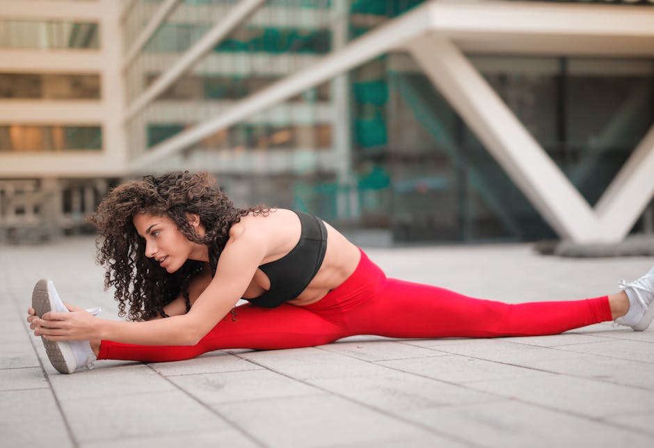 A woman performs a stretching exercise in an urban environment, showcasing flexibility and fitness.