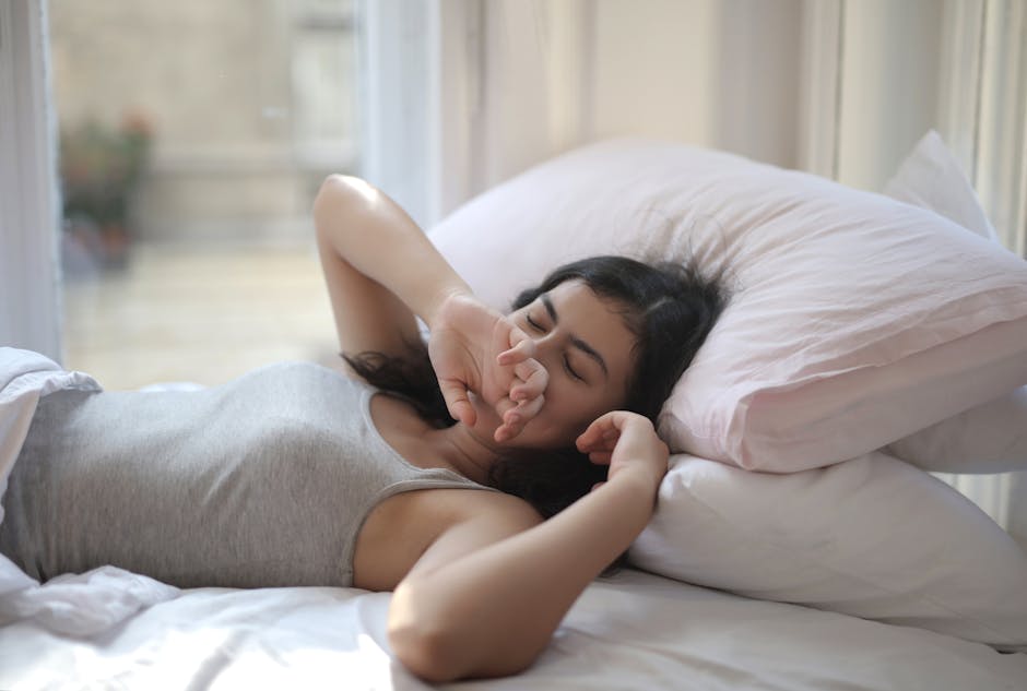 A woman resting comfortably indoors on a cozy bed, perfect for lifestyle or relaxation themes.