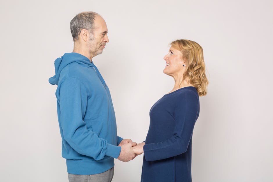 Elderly couple sharing a joyful moment, holding hands and smiling at each other.
