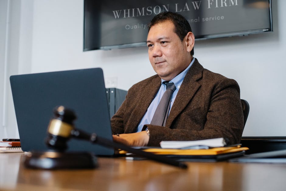 Content adult Asian male lawyer in elegant formal suit surfing contemporary netbook while working in respectable law firm
