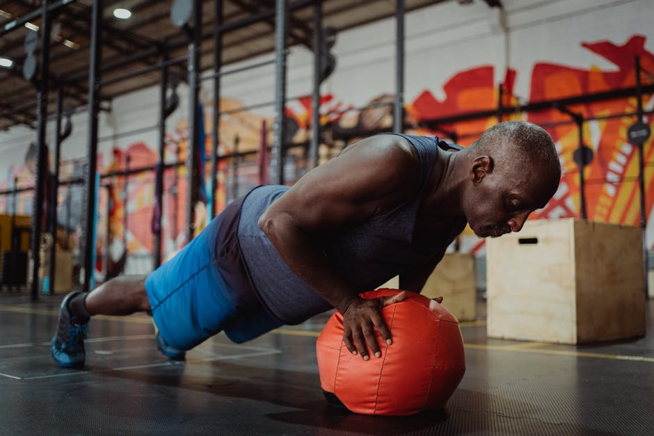 Focused man doing a one-arm push-up on a gym ball in a vibrant indoor gym setting.