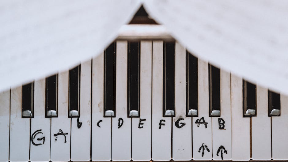 A close-up view of piano keys with musical notes marked by hand, showing educational and learning aids.