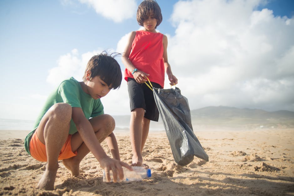 Two boys collect plastic waste on a sunny beach in Portugal, fostering environmental consciousness.