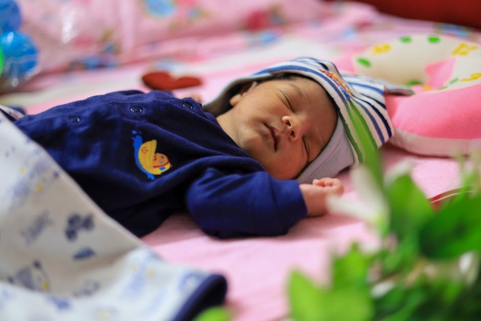 Charming image of a newborn baby peacefully sleeping on a colorful bed with soft toys.