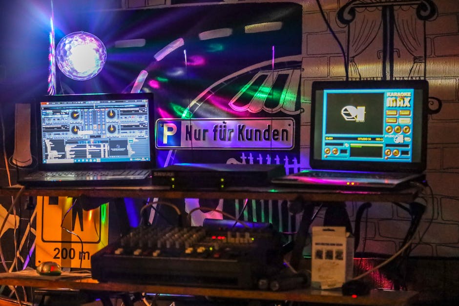 A dynamic DJ booth setup in a nightclub illuminated with colorful neon lights and bustling electronic equipment.