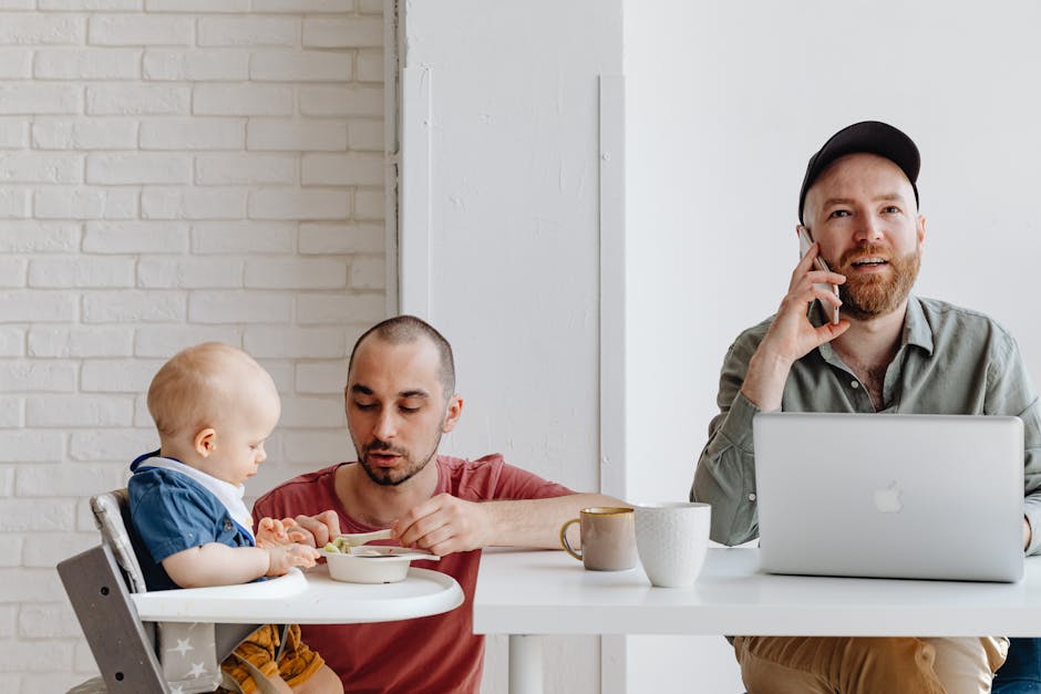 Happy gay couple with their baby enjoying a meal and work at home.