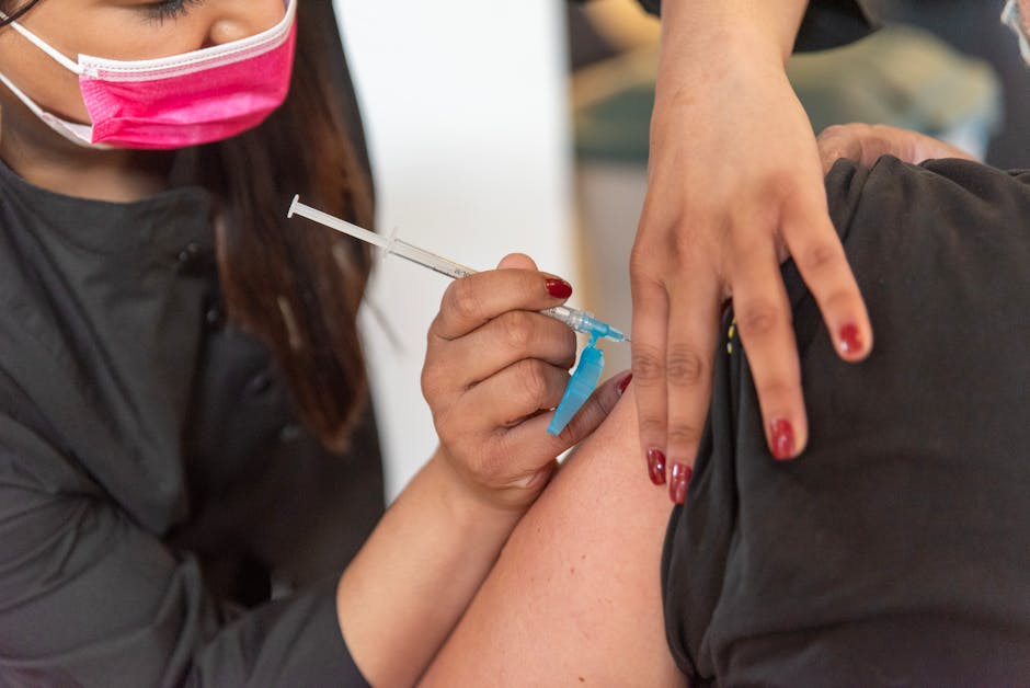 Close-up of a healthcare worker giving a vaccination shot to a patient indoors.