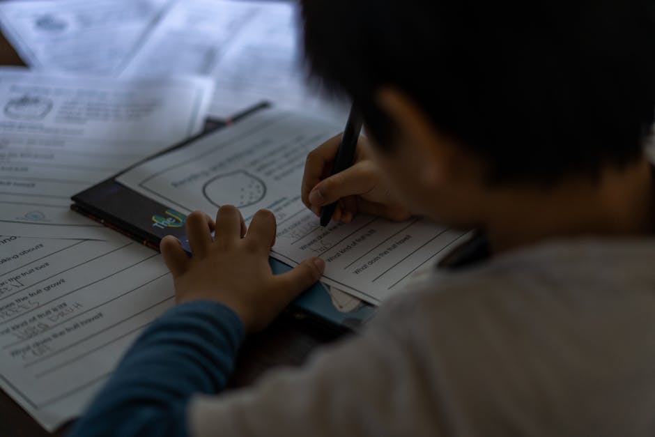 Young child focused on writing homework indoors. Educational and learning concept.