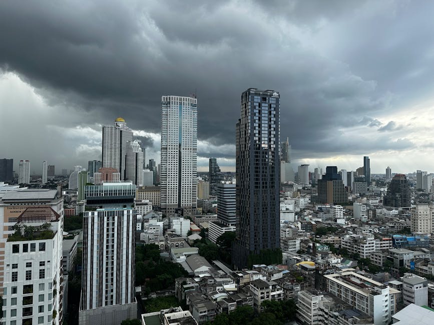 High-angle view of Bangkok's skyline with storm clouds gathering overhead, adding a dramatic touch.