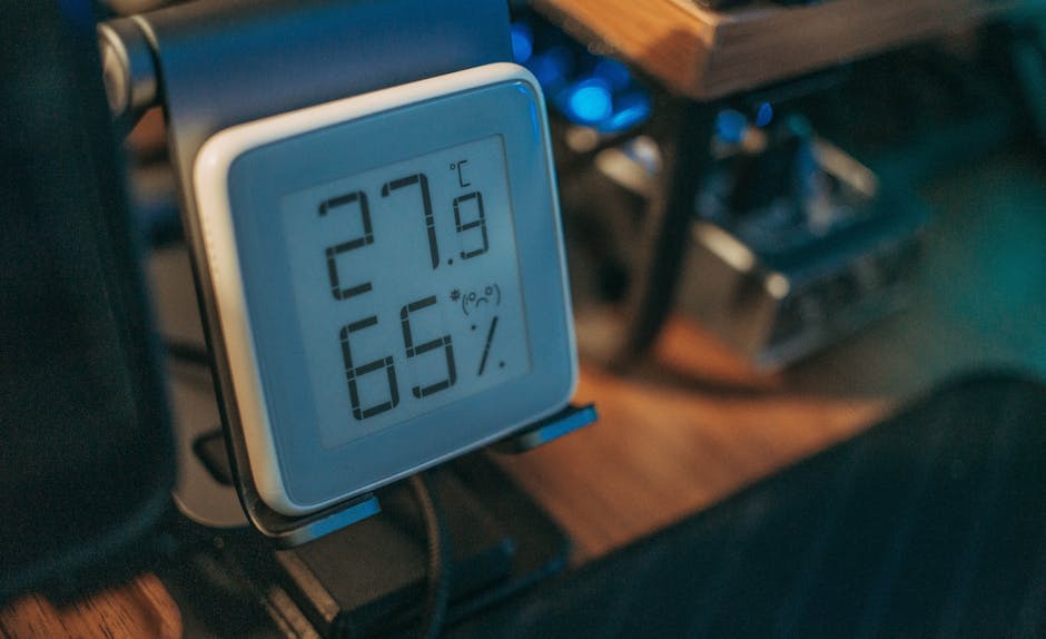 Close-up of a digital hygrometer showing temperature and humidity indoors.