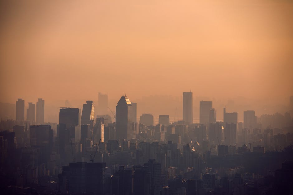 Aerial view of Seoul's skyline enveloped in fog during sunset, showcasing modern architecture.