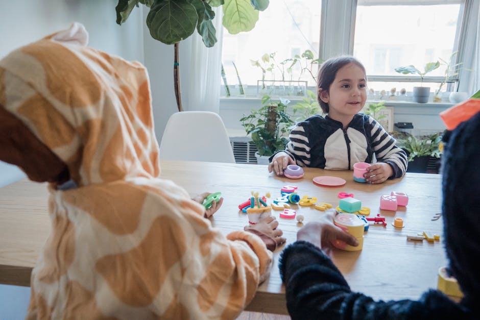 Kids enjoy playtime in colorful animal costumes indoors with toy tea set.
