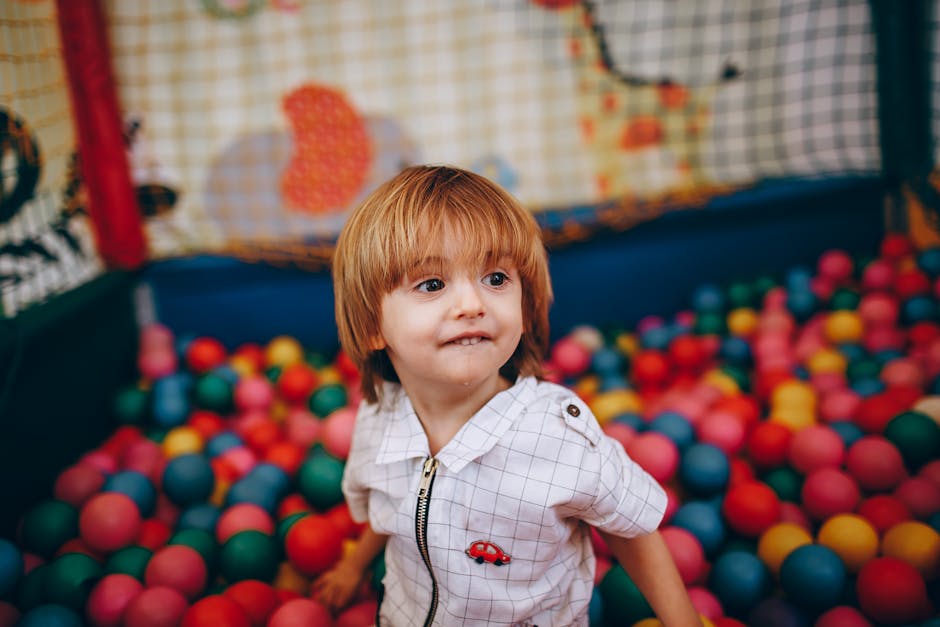 Adorable child having fun in a vibrant indoor playground ball pit.