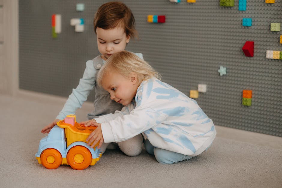 Two young children playing with a colorful toy truck in an educational indoor setting.