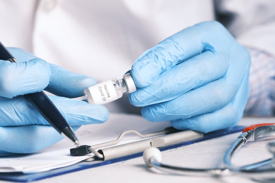 Close-up of a doctor's hands holding a COVID-19 vaccine vial, wearing gloves.