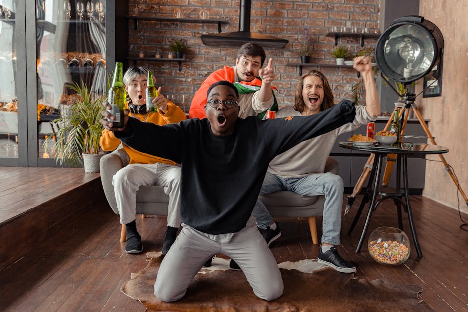 Group of diverse friends celebrating a sports event indoors with drinks and snacks.