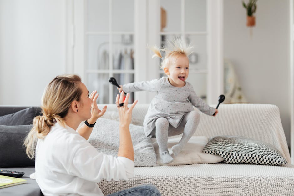 Mother and daughter enjoying a playful moment on the living room sofa.