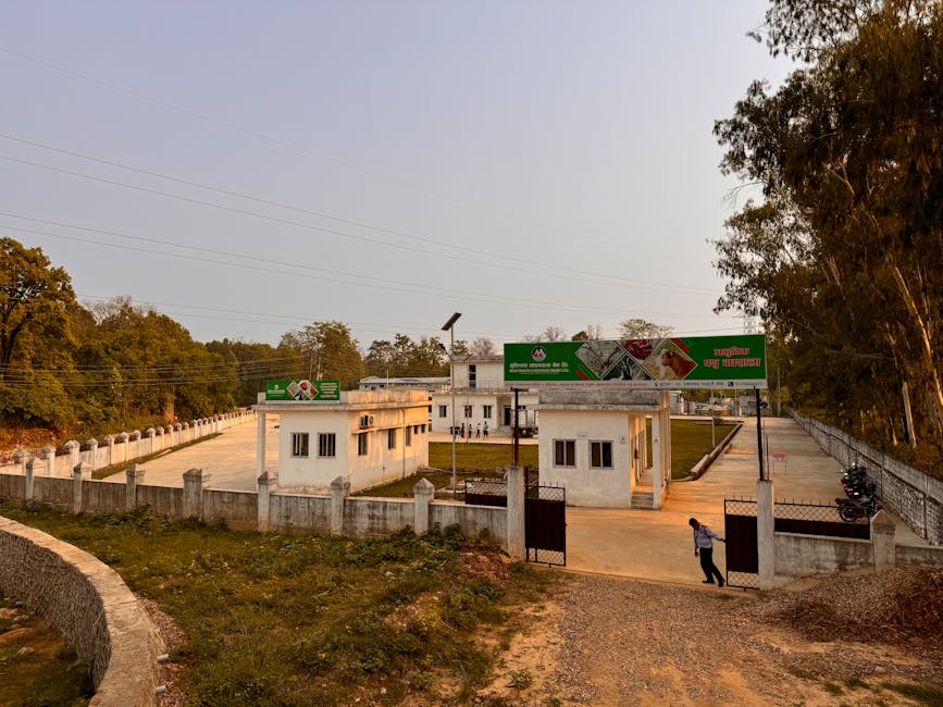 A rural facility with an open gate, surrounded by trees and a sunset sky, presents a peaceful rural setting.